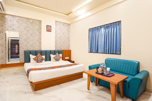 a hotel room with a bed and a table at FabHotel Sunrise Comforts in Pune