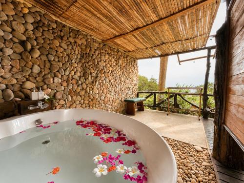 a bathroom with a bath tub with flowers in it at Ting Rai Bay Resort in Ko Jum