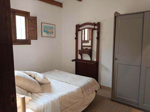 a bedroom with a bed and a mirror on the wall at casita la bugamvilla in Mojácar