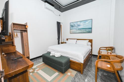 a bedroom with a bed and a desk and a television at Dewandaru Homestay 1 in Tonogoro