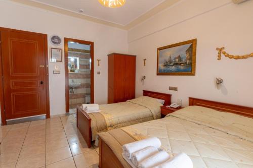 a bedroom with two beds and a bathroom with a sink at VILLA Vasilios EXARHOS in Paralia Katerinis