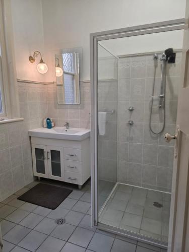a bathroom with a shower and a sink at The Red Manor on Mort in Lithgow