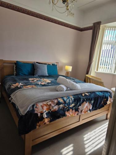 a bedroom with a bed with a blue comforter at The Red Manor on Mort in Lithgow