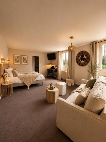 a living room with a bed and a couch at Hôtel Le Clos des Arts in Gevrey-Chambertin