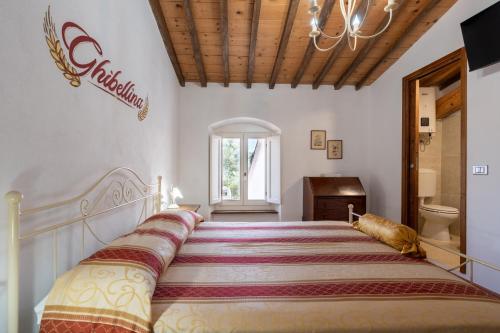 a large bed in a bedroom with a large bedspread at La Campana d'Oro Bibbiena in Bibbiena