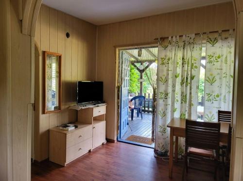 a living room with a television and a door to a porch at Domek Ostróda in Ostróda