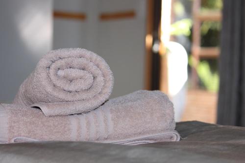 a rolled up towel sitting on top of a table at Villa Mariss Guesthouse in Kraaifontein
