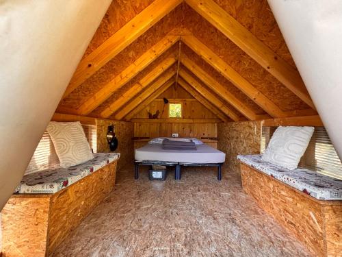 a room with a bed in a wooden house at Camping Osenbach in Osenbach