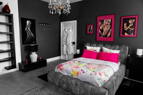 a bedroom with a large bed with pink pillows at LE CHERCHE MIDI Chambres d'hôtes avec CUISINE EQUIPEE grand jardin PARKING SECURISE GRATUIT in Albi