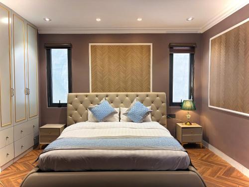 a bedroom with a large bed with blue pillows at Khách Sạn PG Boutique in Vung Tau