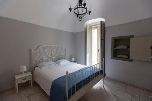 a white bedroom with a bed and a window at Nel Blu Dipinto di Blu - Casa Anemone in Polignano a Mare