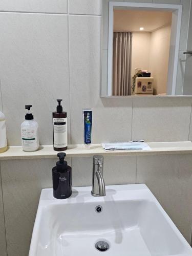 a bathroom sink with a bottle of soap and a mirror at 스테이149 in Hyomoktong-Ilgu