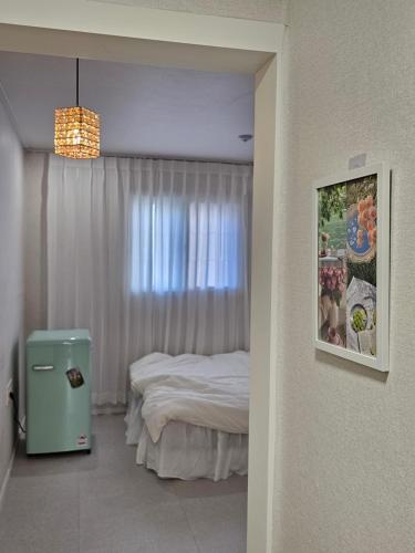 a small bedroom with a bed and a window at 스테이149 in Hyomoktong-Ilgu