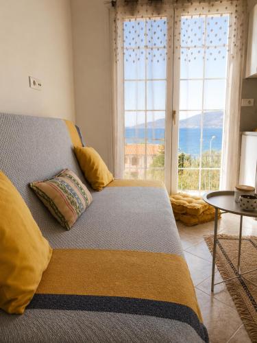 a bedroom with a bed and a large window at Terra Saronia in Metamórfosis