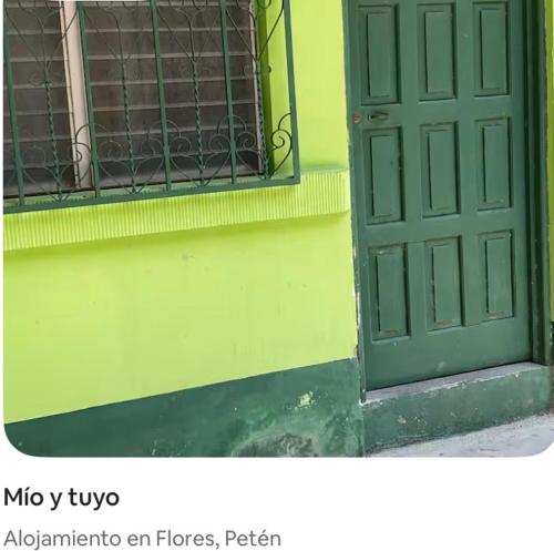 a green door on the side of a building at Mio y tuyo in Flores