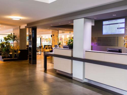 a lobby of a restaurant with a counter at Mercure Lorient Centre in Lorient