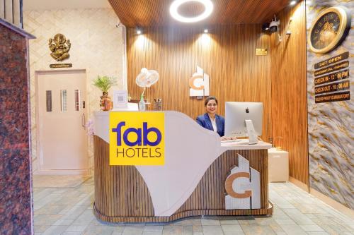 a woman standing at a reception desk in a store at Fabhotel Grant Heights - Nr Biju Patnaik International Airport in Bhubaneshwar