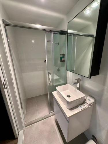 a white bathroom with a shower and a sink at Willows Motel in Goulburn