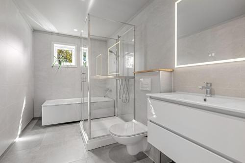 a bathroom with a toilet and a shower and a sink at Beach cottage in Søgne in Kristiansand