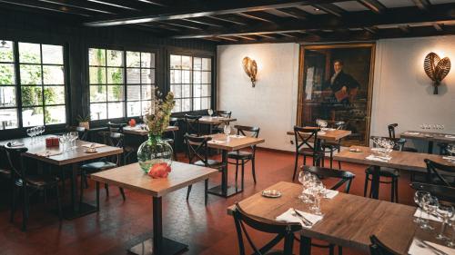 a restaurant with wooden tables and chairs and windows at Auberge Du Roselet in Duingt