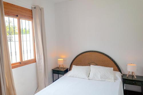 a bedroom with a white bed and a window at Calma house Zahora in Zahora