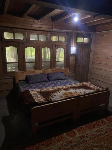 a bedroom with a bed in a room with windows at Kalash Echo Lodge in Chitral