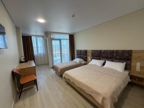 a bedroom with a large bed and a chair at Hotel Royal Georgia 2 in Batumi
