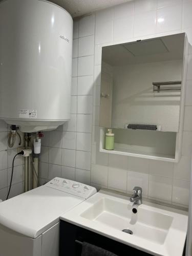 a white bathroom with a sink and a mirror at L'Atelier 37 - Centre Tours in Tours