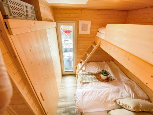 a tiny house with a bunk bed in a room at Hausboot - Yara in Heiligenhafen