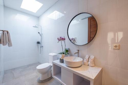 a white bathroom with a sink and a mirror at Emerald Villas Canggu in Canggu