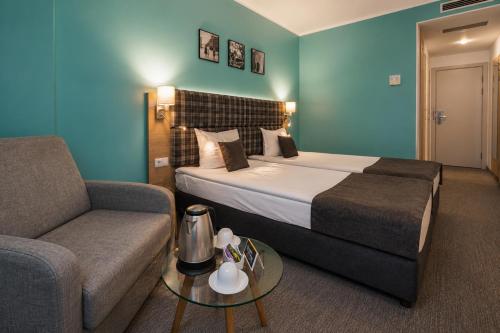 a hotel room with a bed and a couch at Aqua Hotel in Varna City