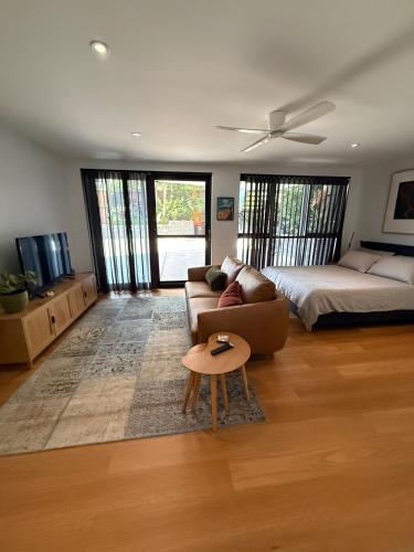a living room with a couch and a bed and a table at Modern Studio in Sydney