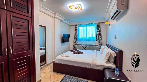 a small bedroom with a bed and a window at Residence Le Carat in Douala