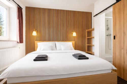 a bedroom with a large white bed and a shower at Forest House near Klínovec with 5 Independent Apartments in Kovářská