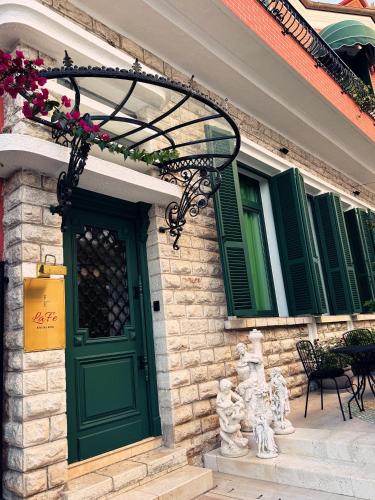 a building with a green door and green windows at LaFe Boutique Hotel in Sarandë