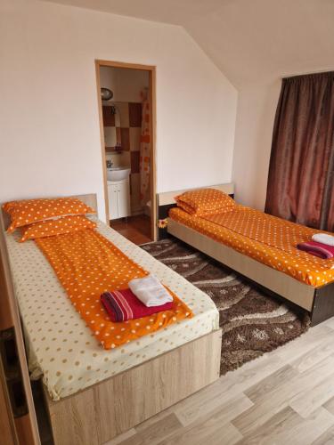 two twin beds in a room with an orange mattress at apartament maia 2 in Turda