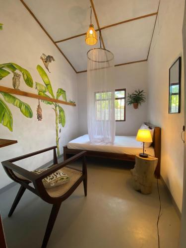 a room with a bed and a chair and a lamp at Indiana villa Koggala in Koggala