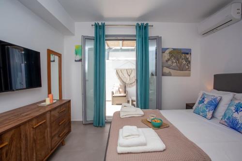 a bedroom with a large bed with blue curtains at Whisper Villa Mykonos in Ano Mera