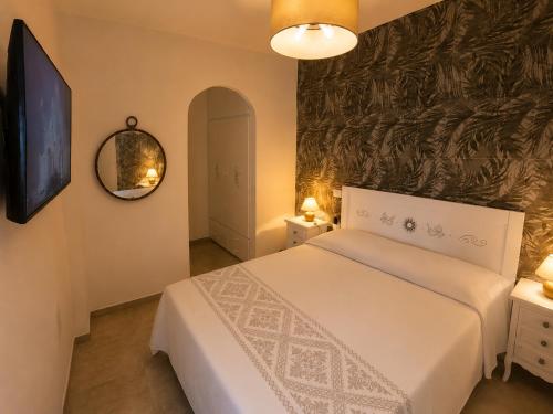 a bedroom with a white bed and a mirror at NEW 2026 - Villa Rafael in Porto Rafael