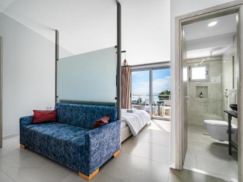 a blue couch in a bathroom with a bedroom at Vourtaréa Guesthouse in Himare