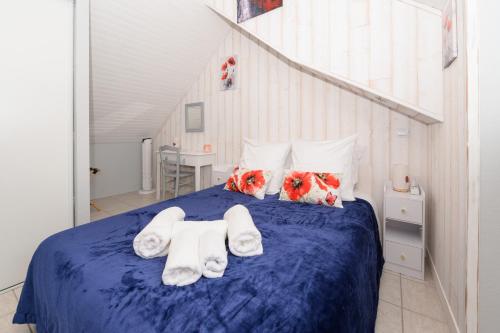 a bedroom with a blue bed with white towels at Maison Ty Bao in Sarzeau