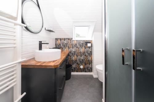a bathroom with a sink and a mirror at Maison Ty Bao in Sarzeau