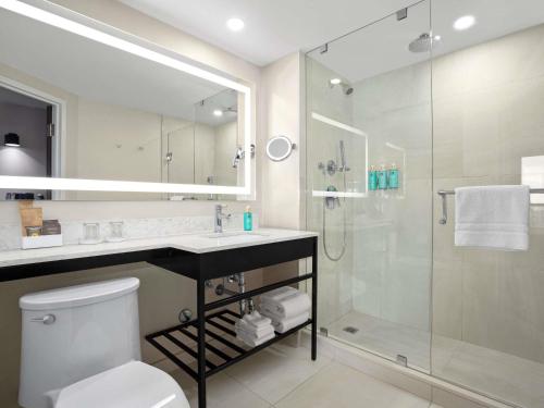 ein Badezimmer mit Dusche, Toilette und Waschbecken in der Unterkunft The Novotel Toronto Centre in Toronto
