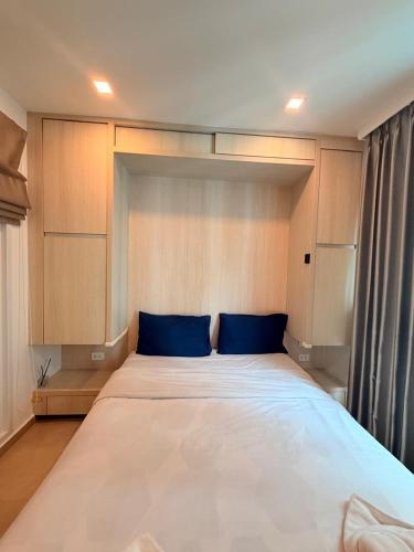 a large bed with blue pillows in a room at City Garden Olympus Condo By Vacation Vibes in Pattaya South