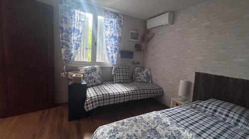 a bedroom with a bed and a chair and a window at Les Freds in Ventavon
