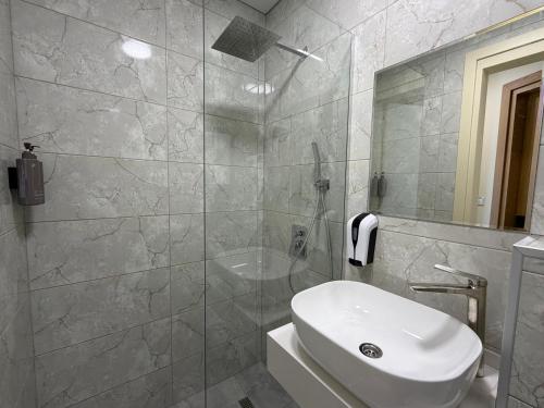 a bathroom with a white sink and a shower at Hotel Royal Georgia 2 in Batumi