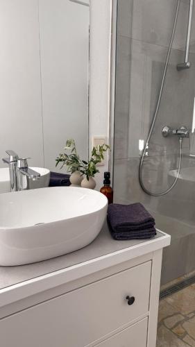 a bathroom with a white sink and a shower at Philia-Modern Living with Panoramic Sea View in Kotrónion