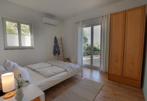 a bedroom with a bed and a sliding glass door at Philia-Modern Living with Panoramic Sea View in Kotrónion