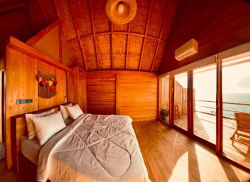 a bedroom with a bed in a room with a balcony at Aresona Cliff House in Bira