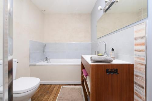 a bathroom with a tub and a toilet and a sink at Le Rockin' Chair in Surzur